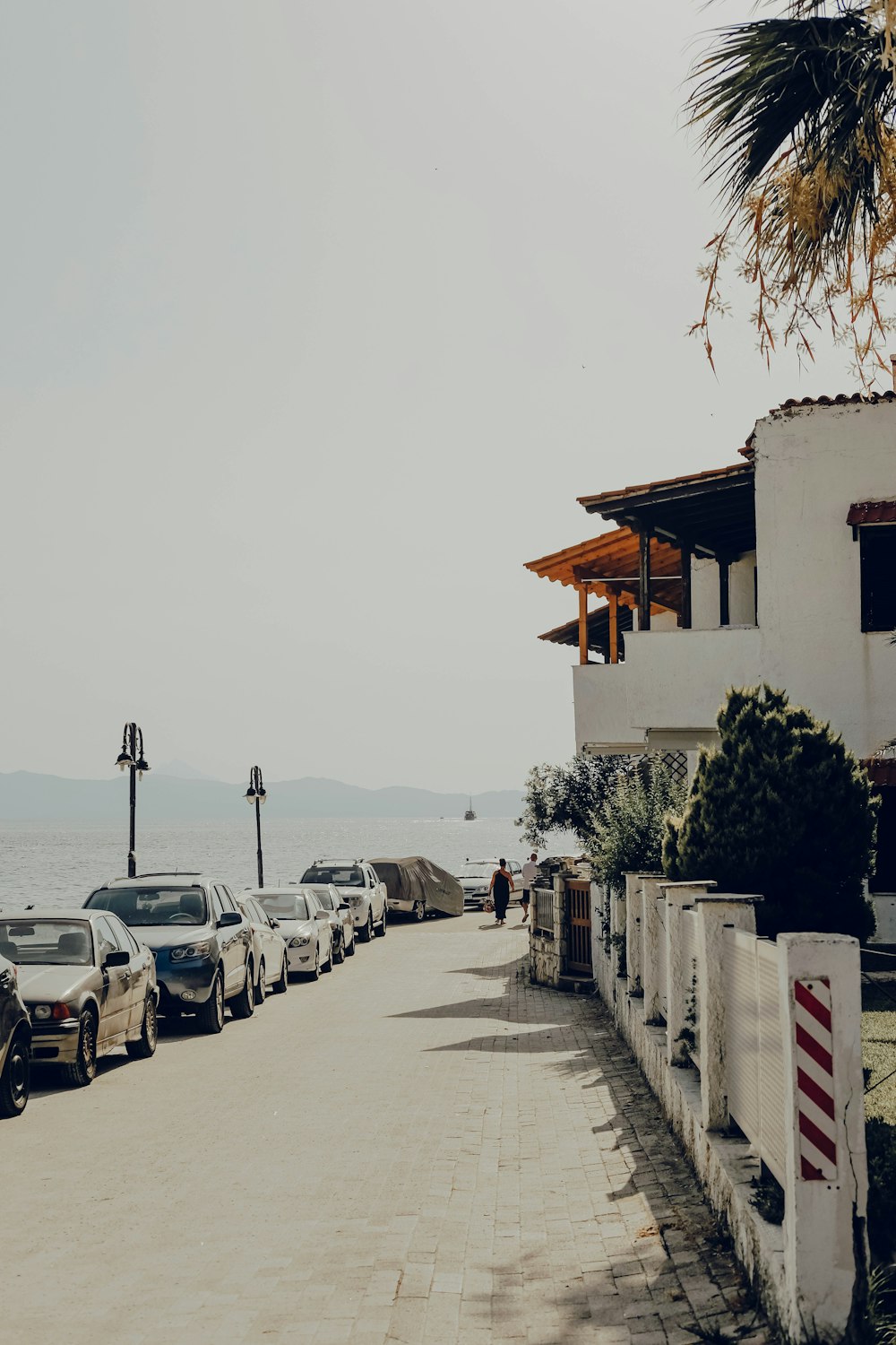 a row of parked cars sitting next to the ocean