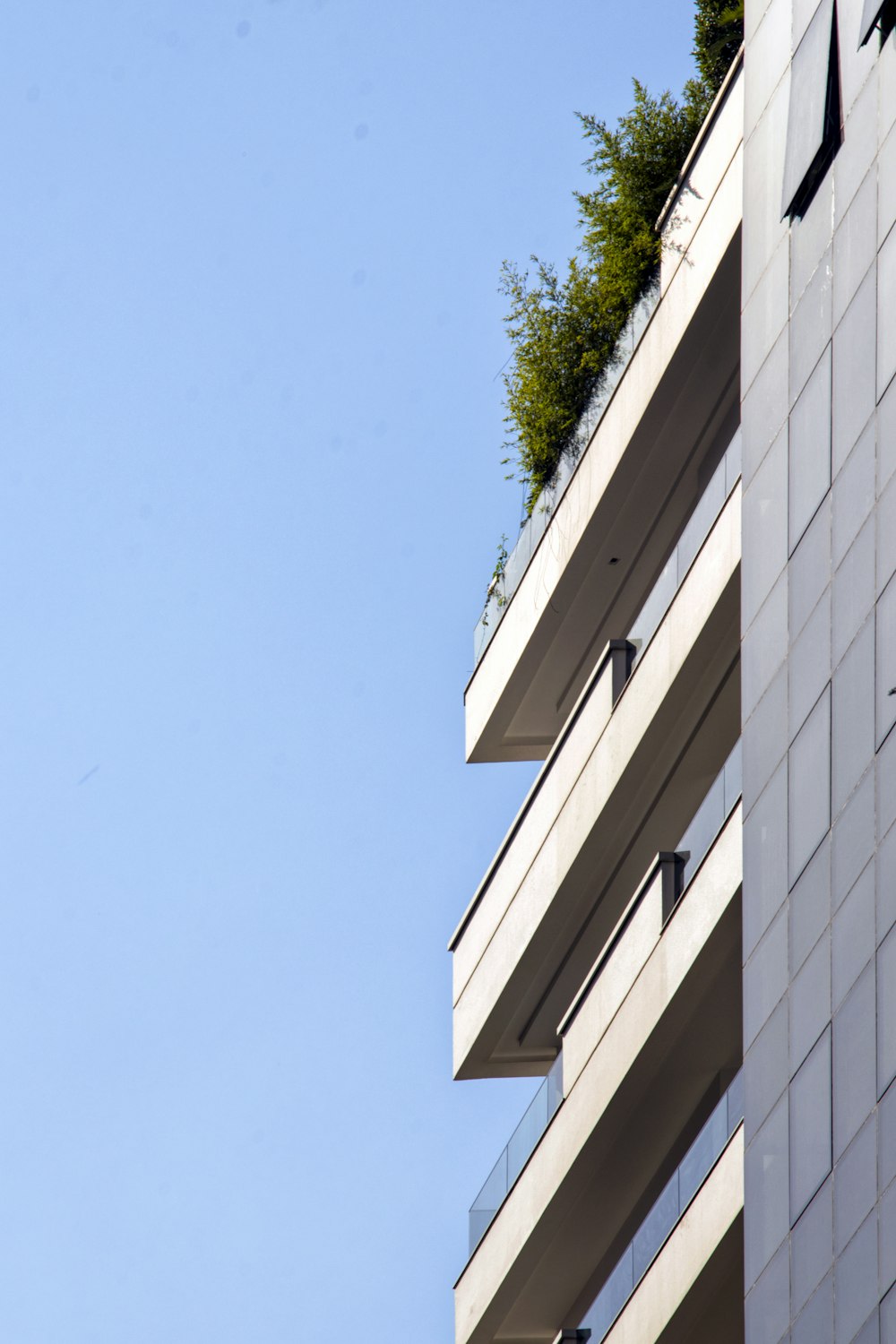 a tall white building with a green roof