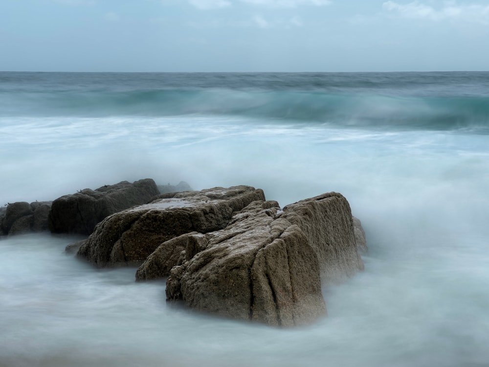 a large rock in the middle of a body of water