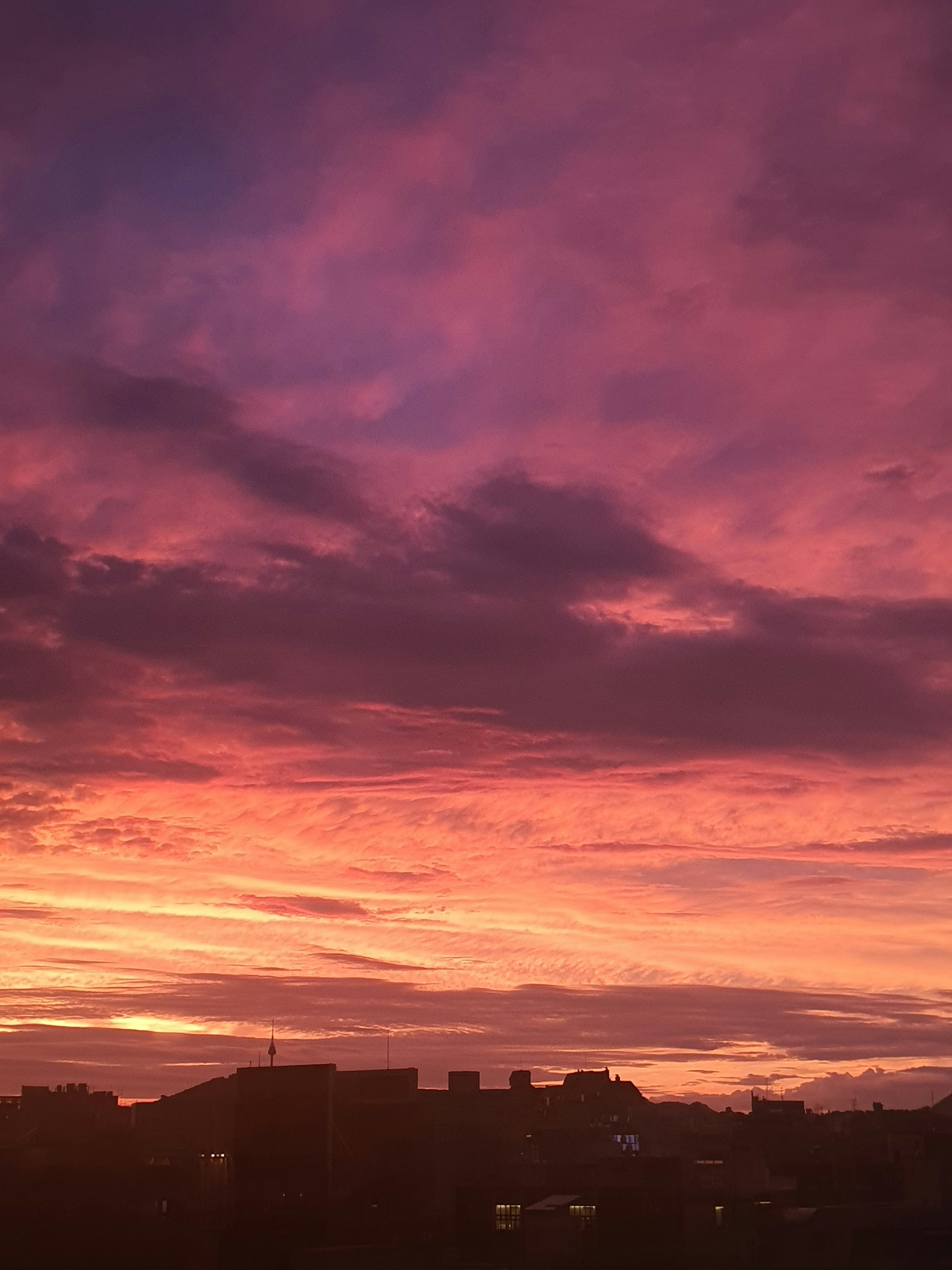 a plane flying in the sky with a sunset in the background