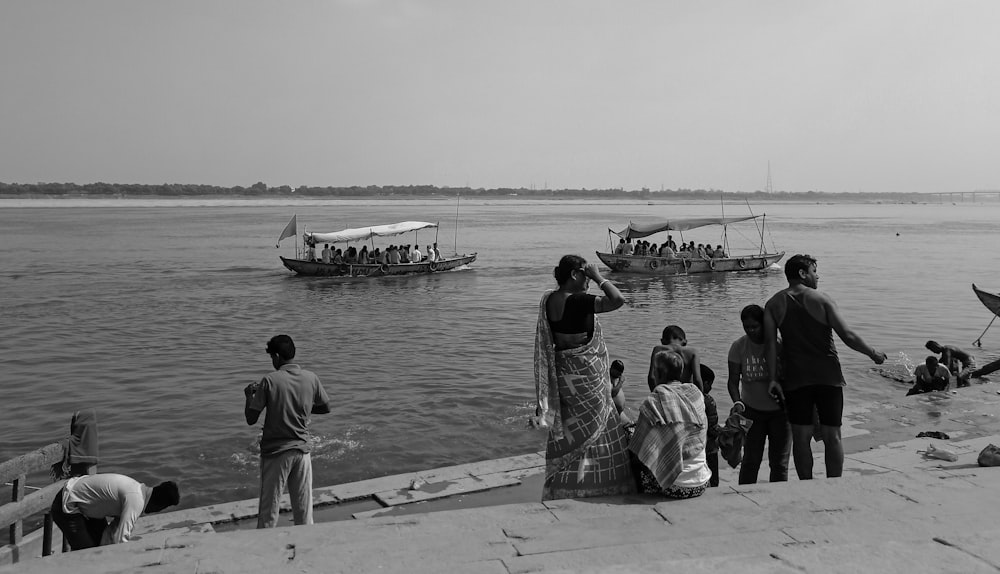 a group of people standing next to a body of water