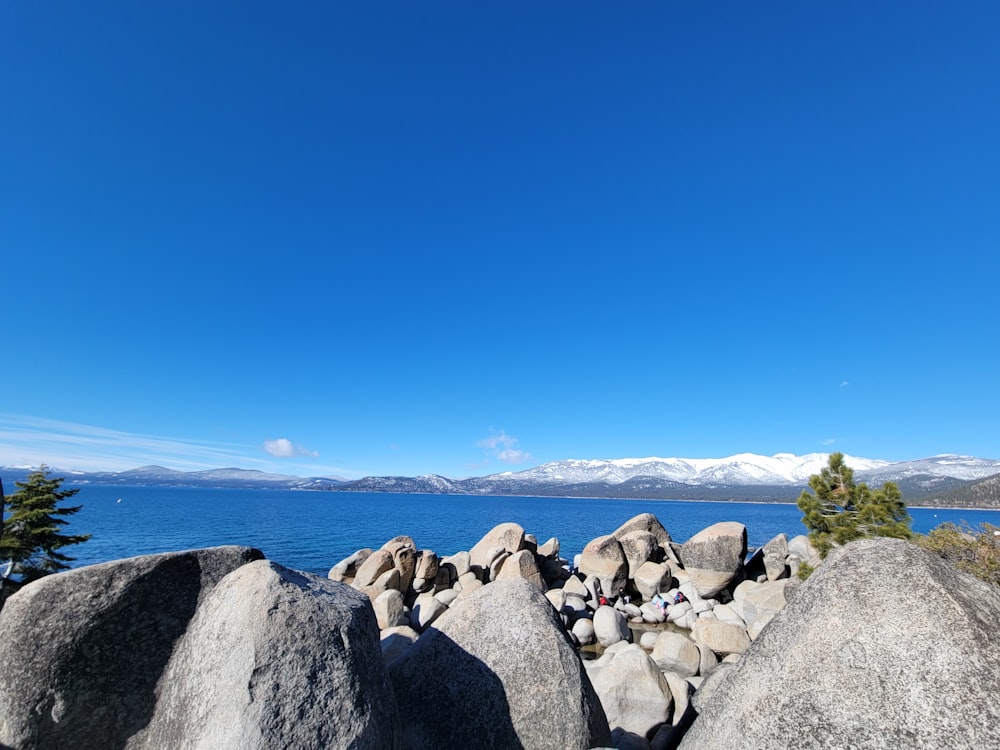 a clear blue sky over some rocks and water