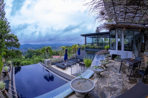 a large swimming pool surrounded by a lush green hillside