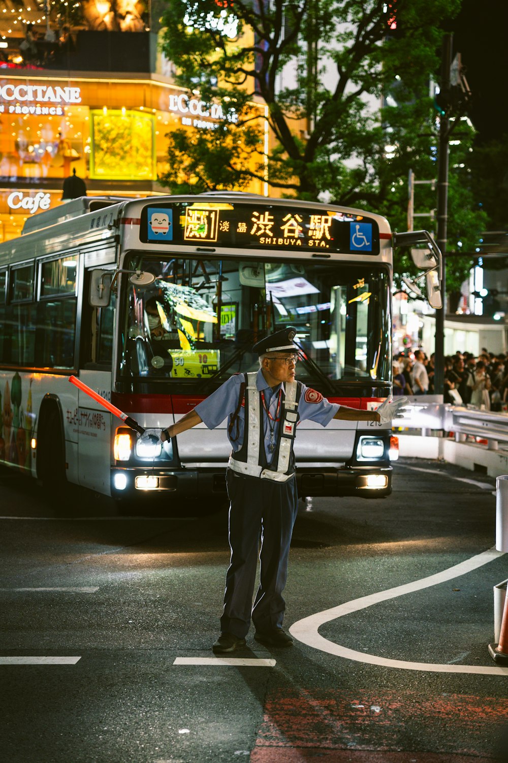 a man standing in front of a bus on a street
