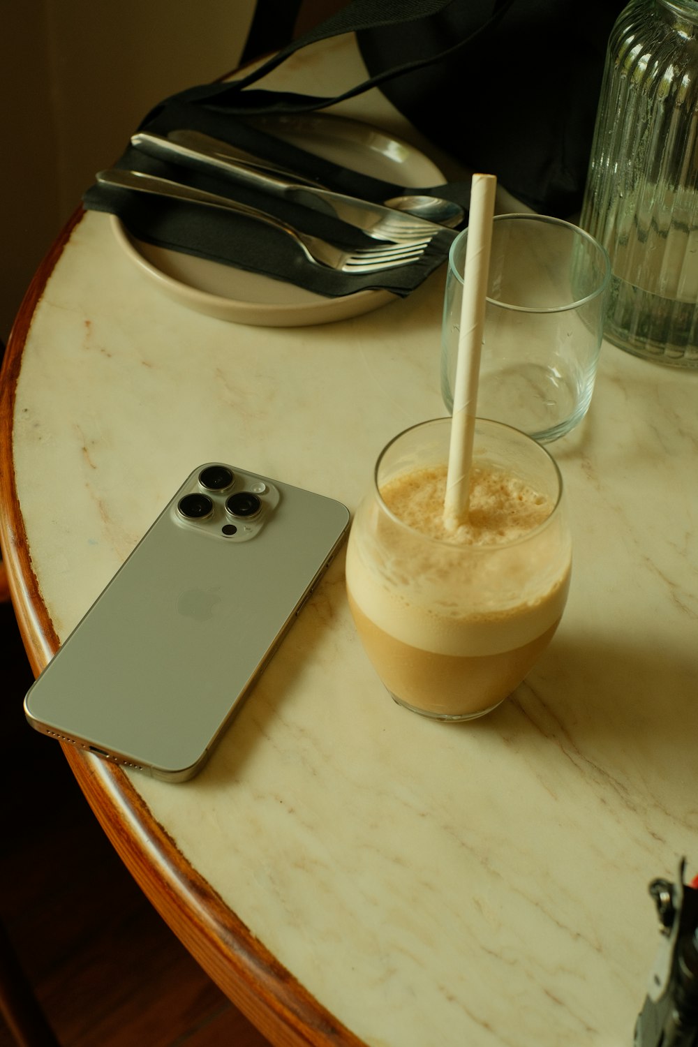 a cell phone sitting on top of a table next to a drink