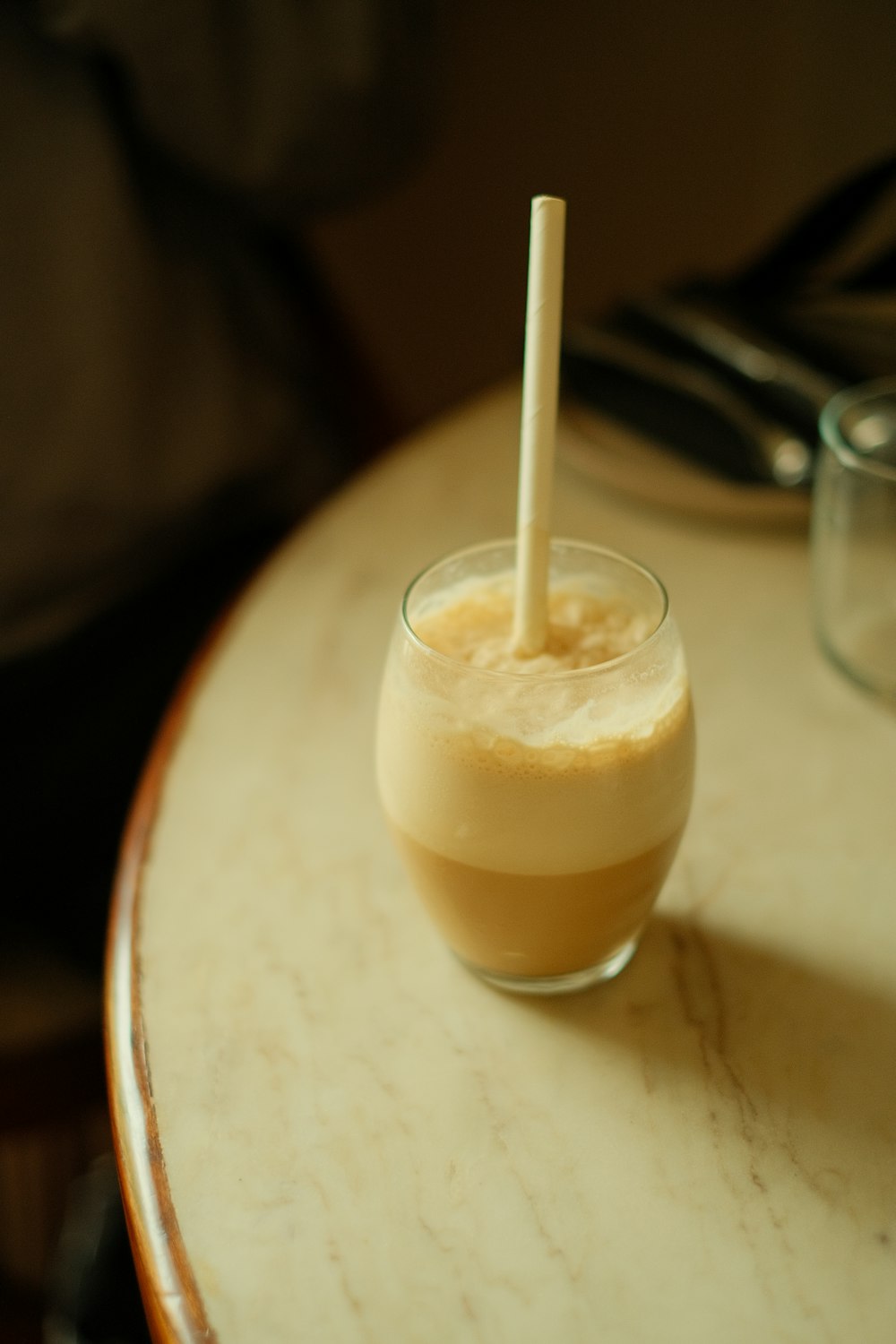 a drink with a straw in it sitting on a table