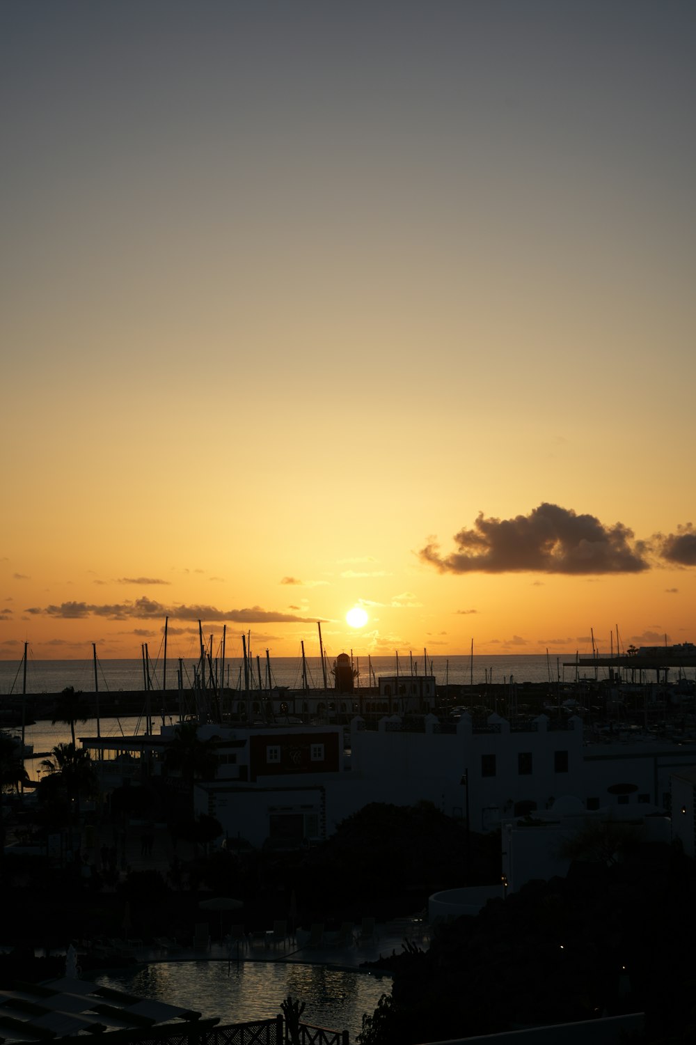 the sun is setting over a harbor with boats