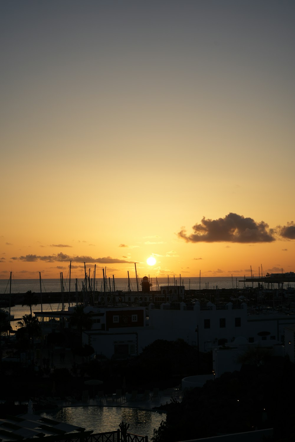 o sol está se pondo sobre um porto com barcos