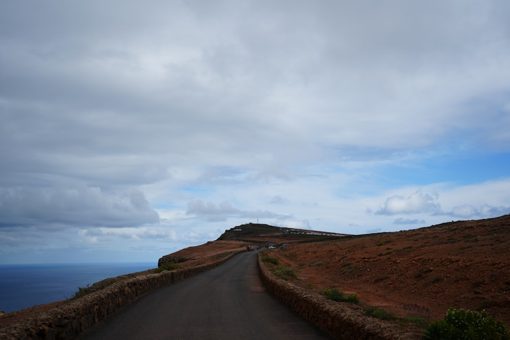 an empty road with a hill in the background