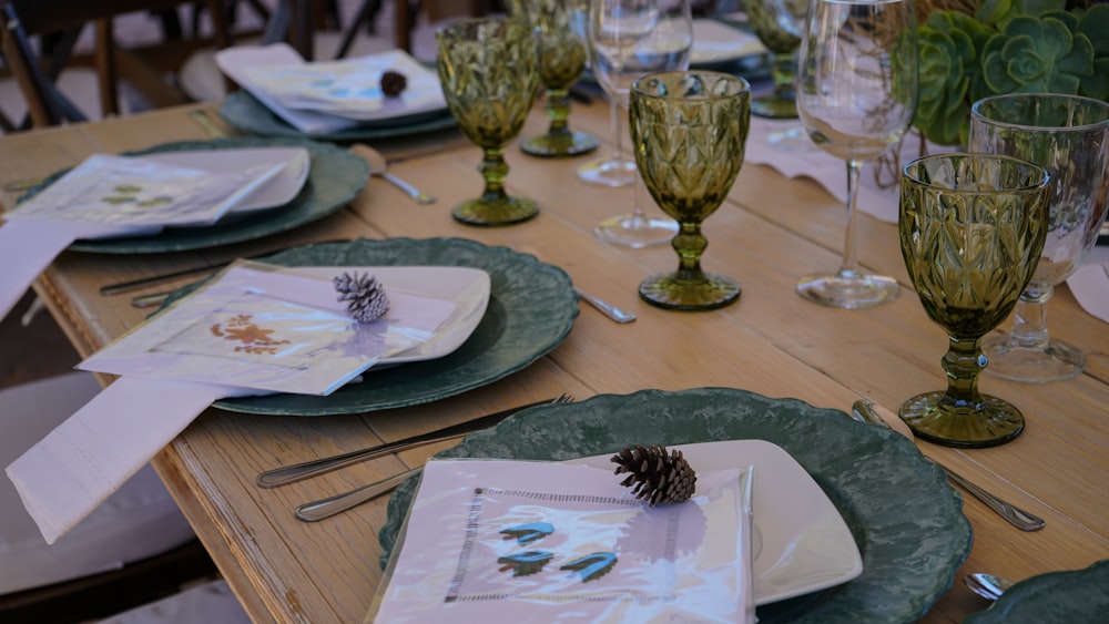 a wooden table topped with plates and glasses