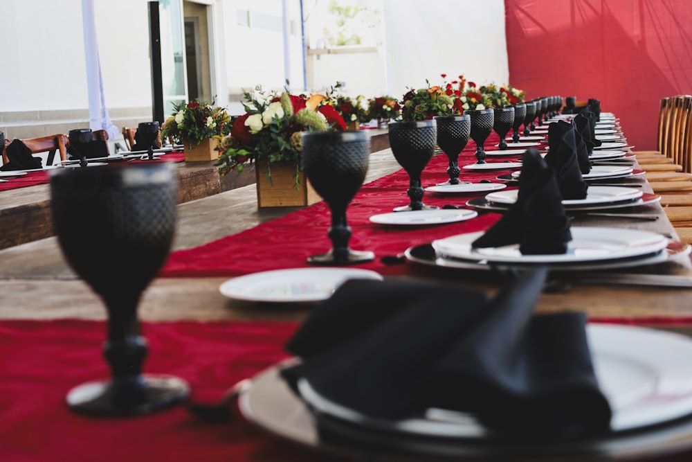 a long table is set with black and white plates