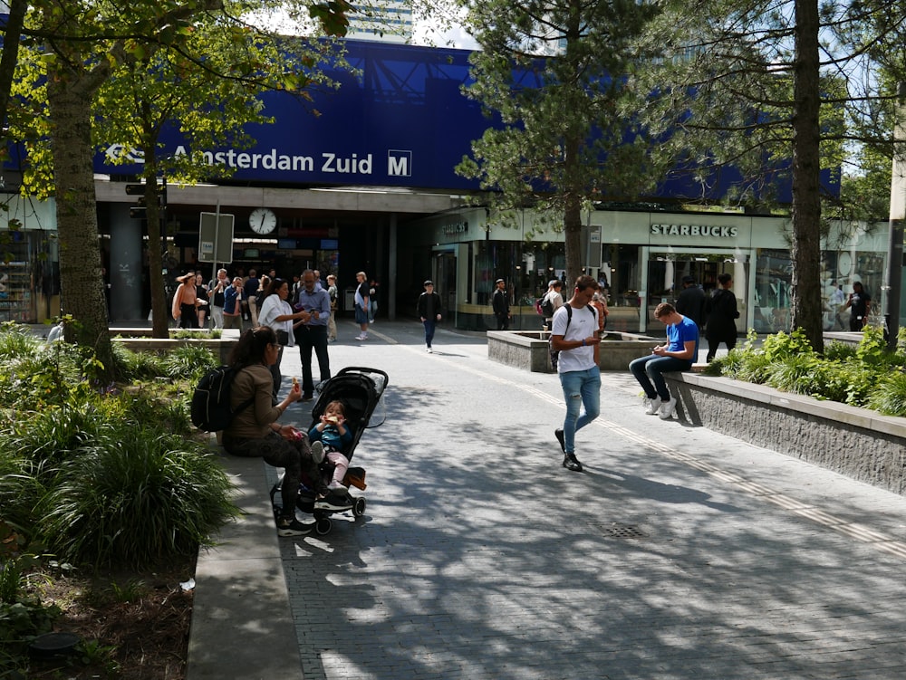 a group of people walking down a street next to trees