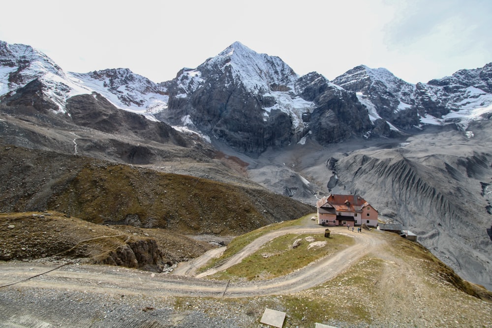 a house on a hill with mountains in the background