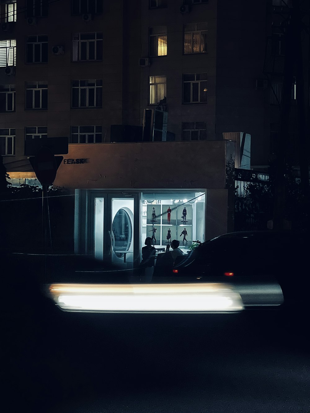 a car passing by a building at night