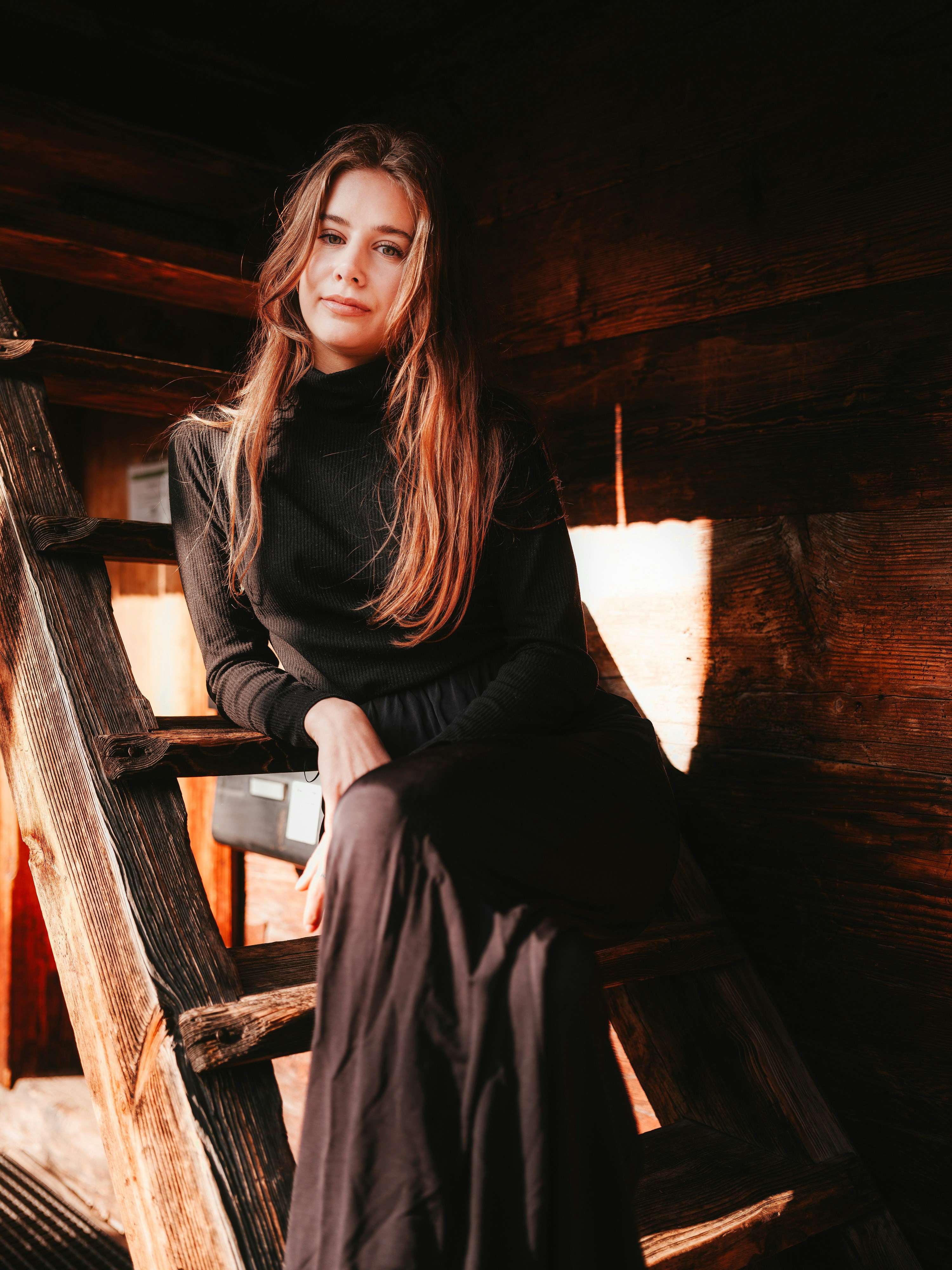 eine Frau, die auf einer Holzleiter sitzt