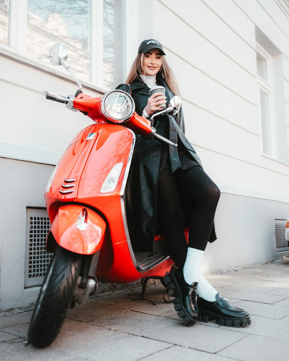 a woman sitting on top of a red scooter