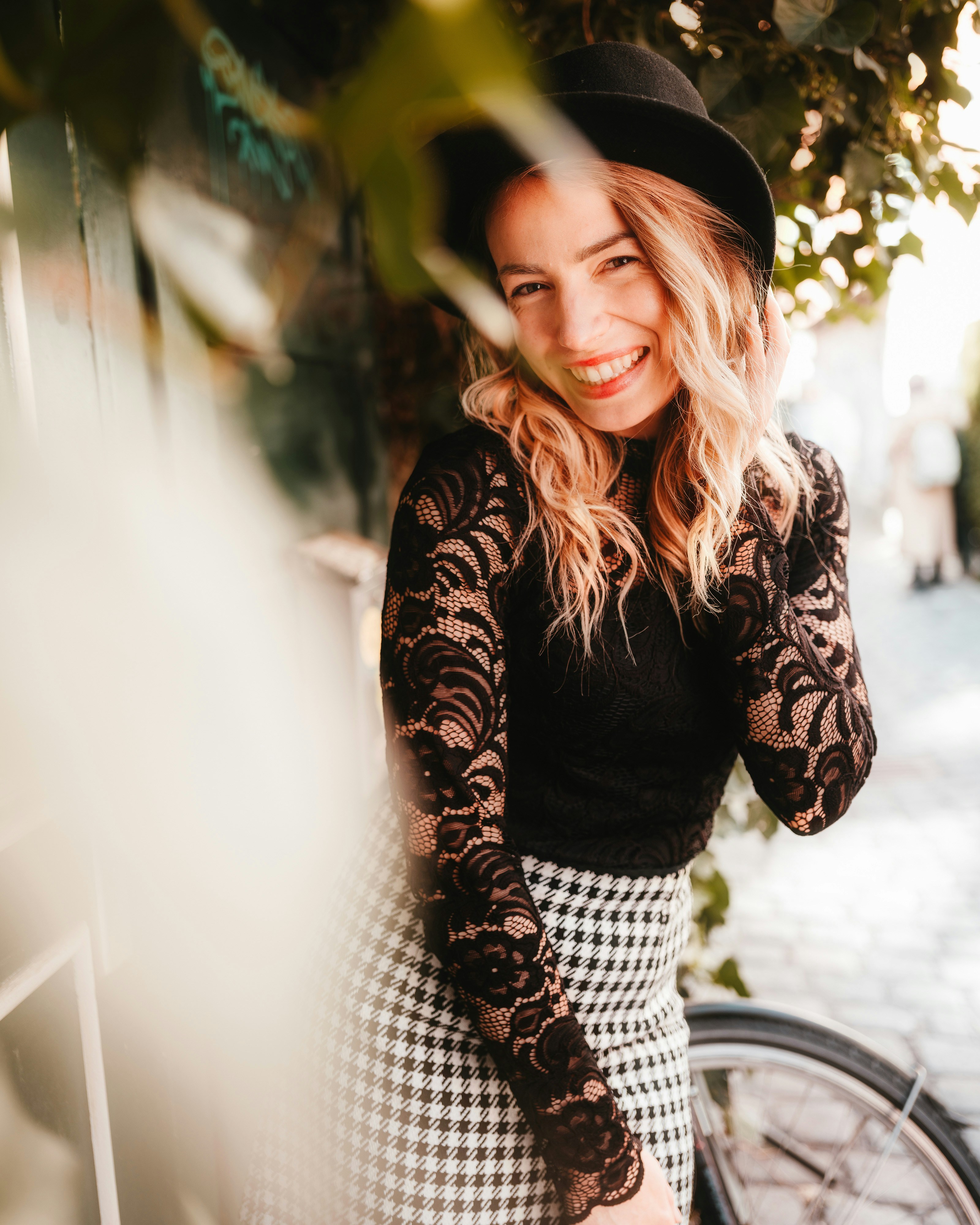 eine Frau, die neben einem Fahrrad steht und einen Hut trägt