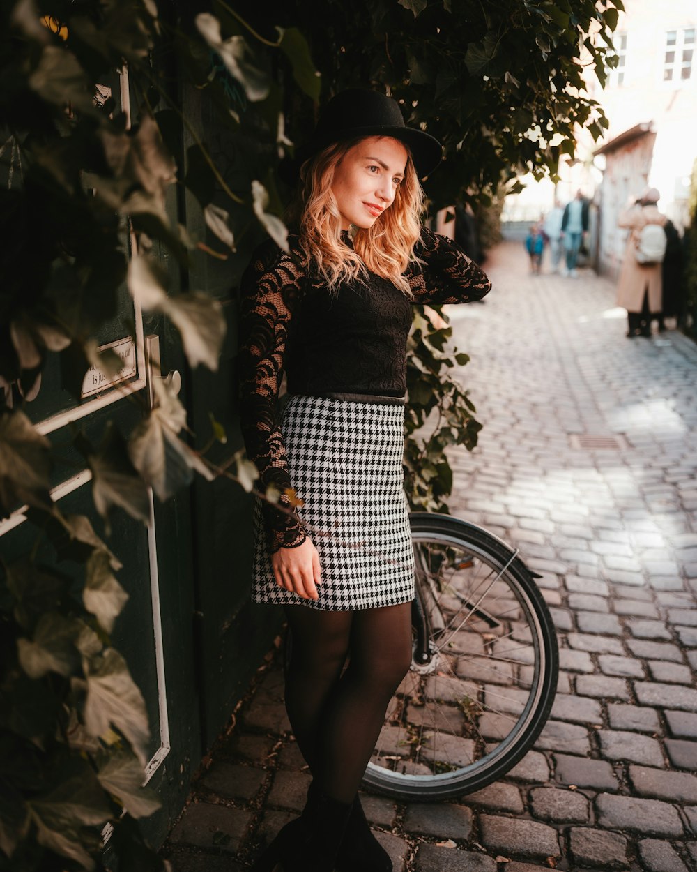 a woman standing next to a bike on a brick road