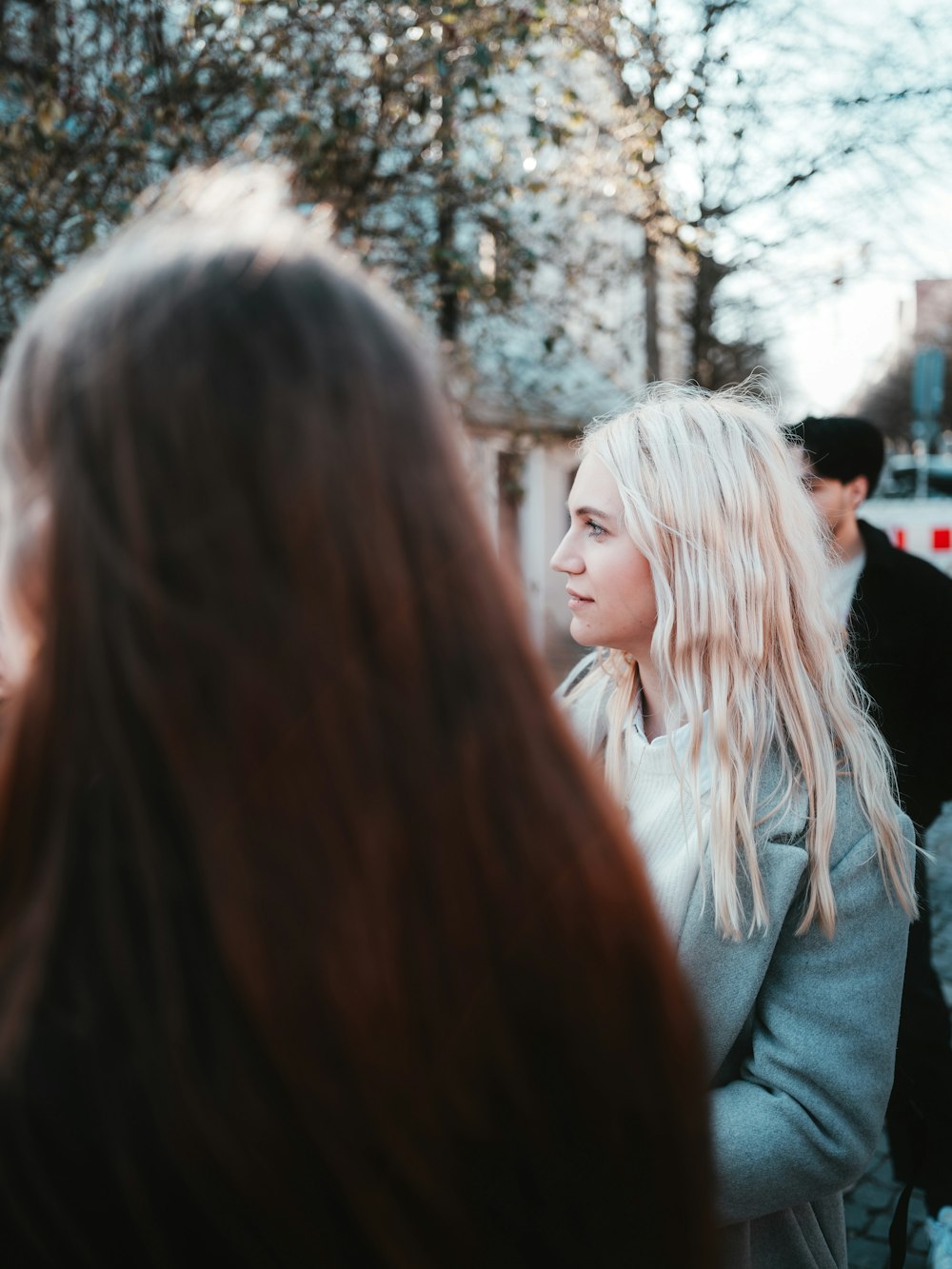 a woman with long blonde hair standing in front of a group of people