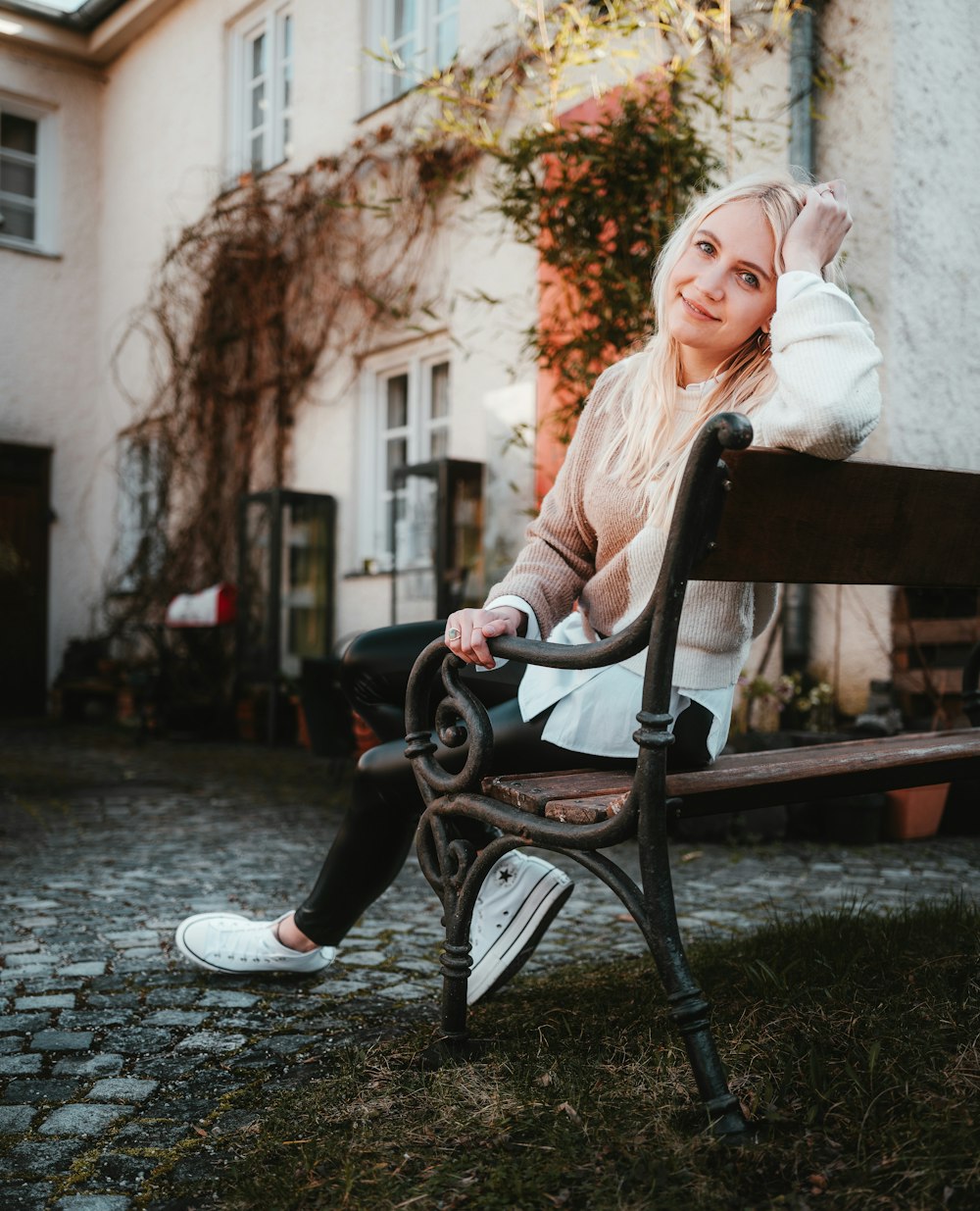 a woman sitting on a bench in front of a building