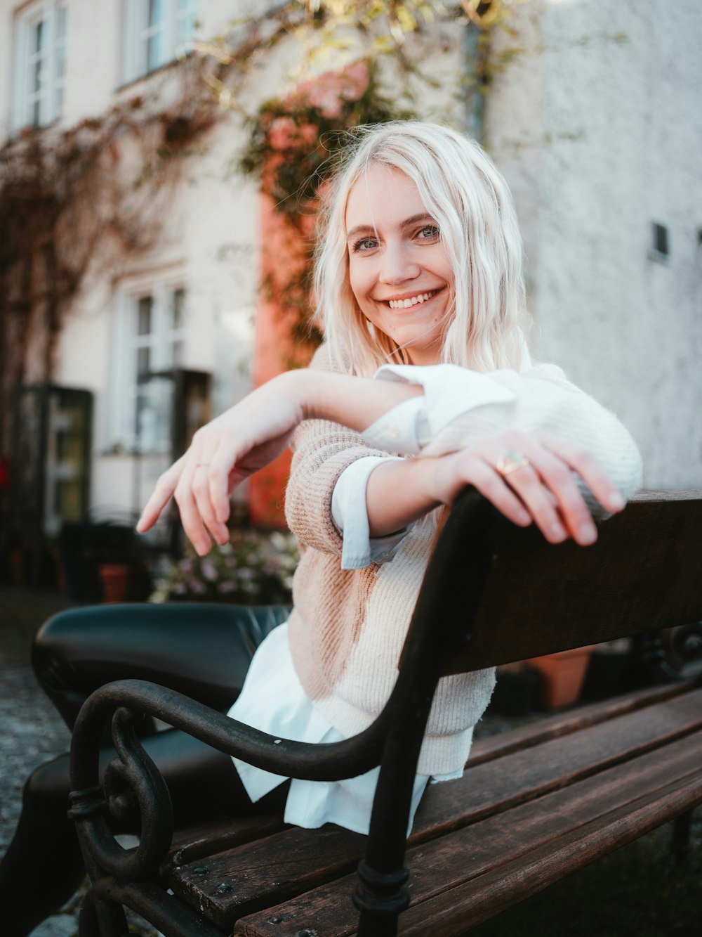 a woman sitting on top of a wooden bench