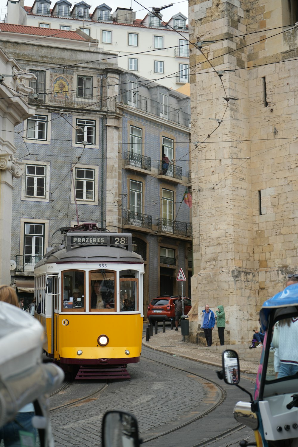 a yellow and white trolley on a city street