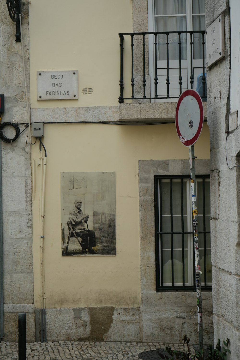 a picture of a man sitting in a chair on the side of a building