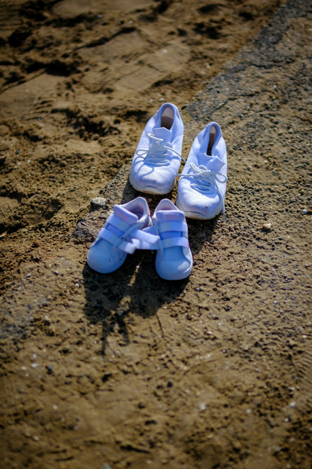 three pairs of baby shoes sitting on the ground