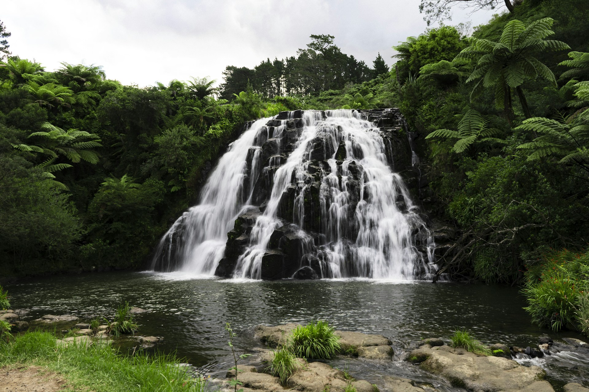 a large waterfall in the middle of a forest