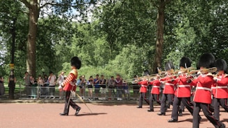 a group of men in uniform marching through a park