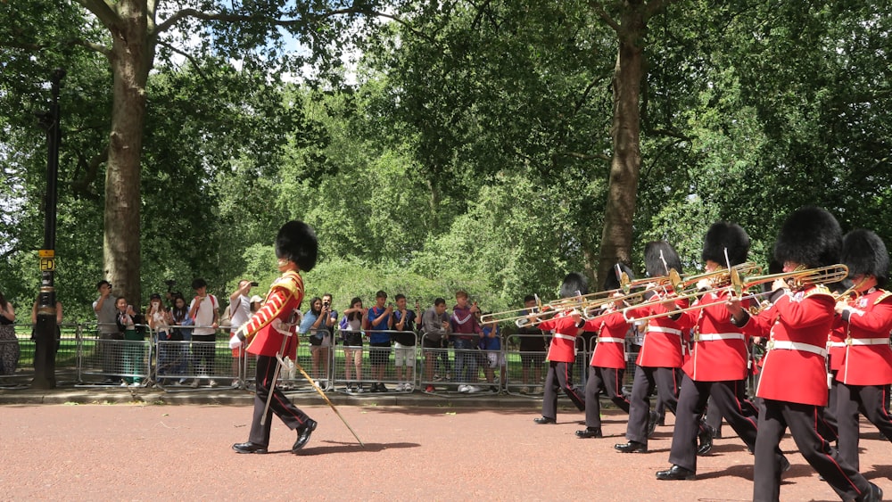 a group of men in uniform marching through a park