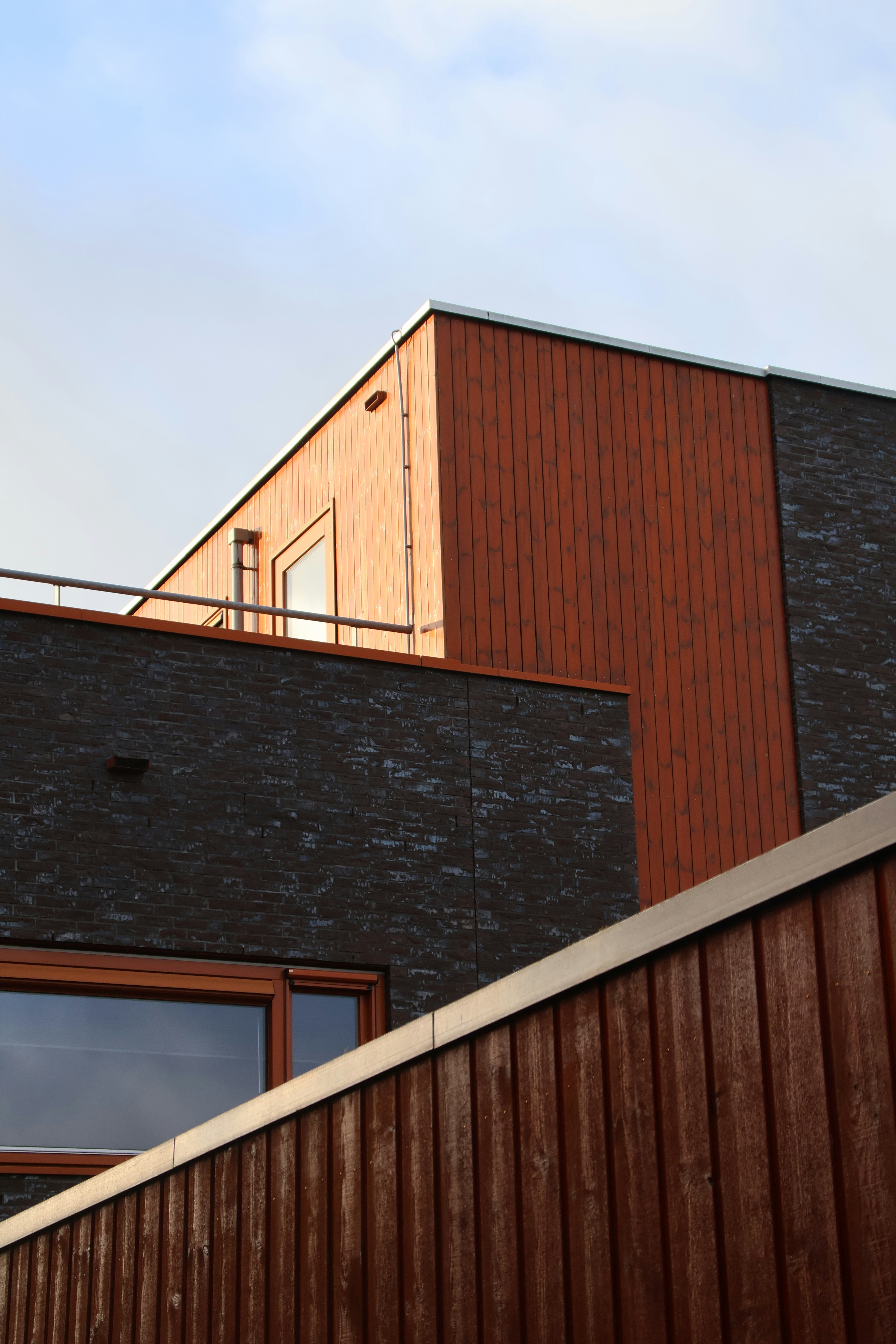 a building with a metal roof and a red brick wall