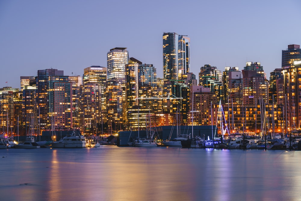 a city skyline at night with boats in the water