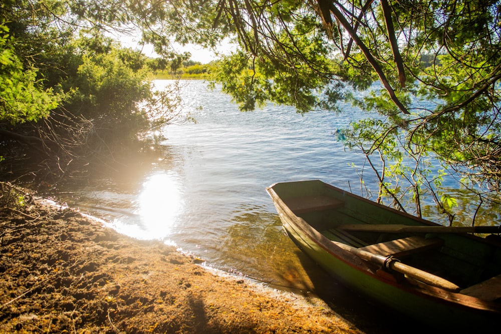 a boat sitting on the shore of a lake