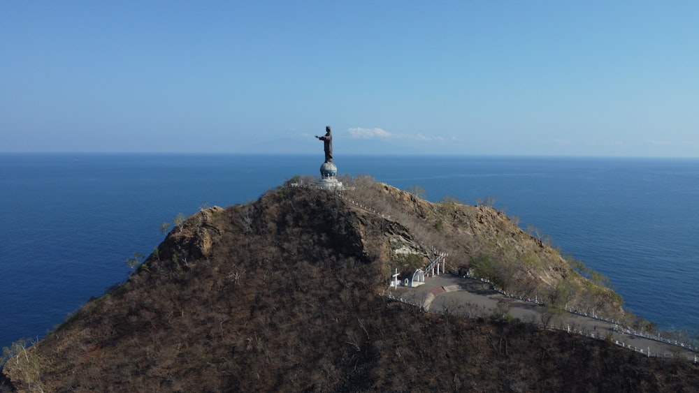 Une statue au sommet d’une montagne surplombant l’océan