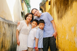 a family poses for a picture in an alleyway