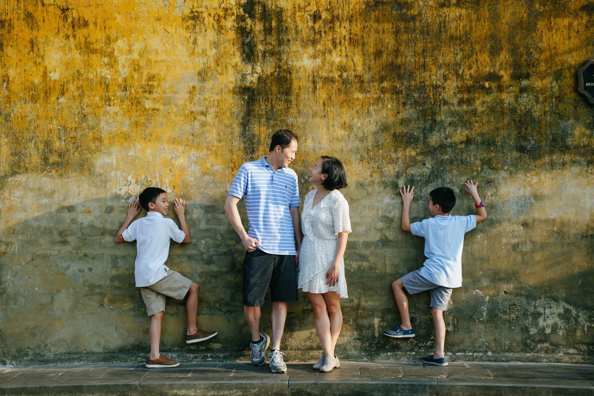 a group of people standing in front of a yellow wall