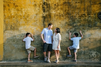 a group of people standing in front of a yellow wall