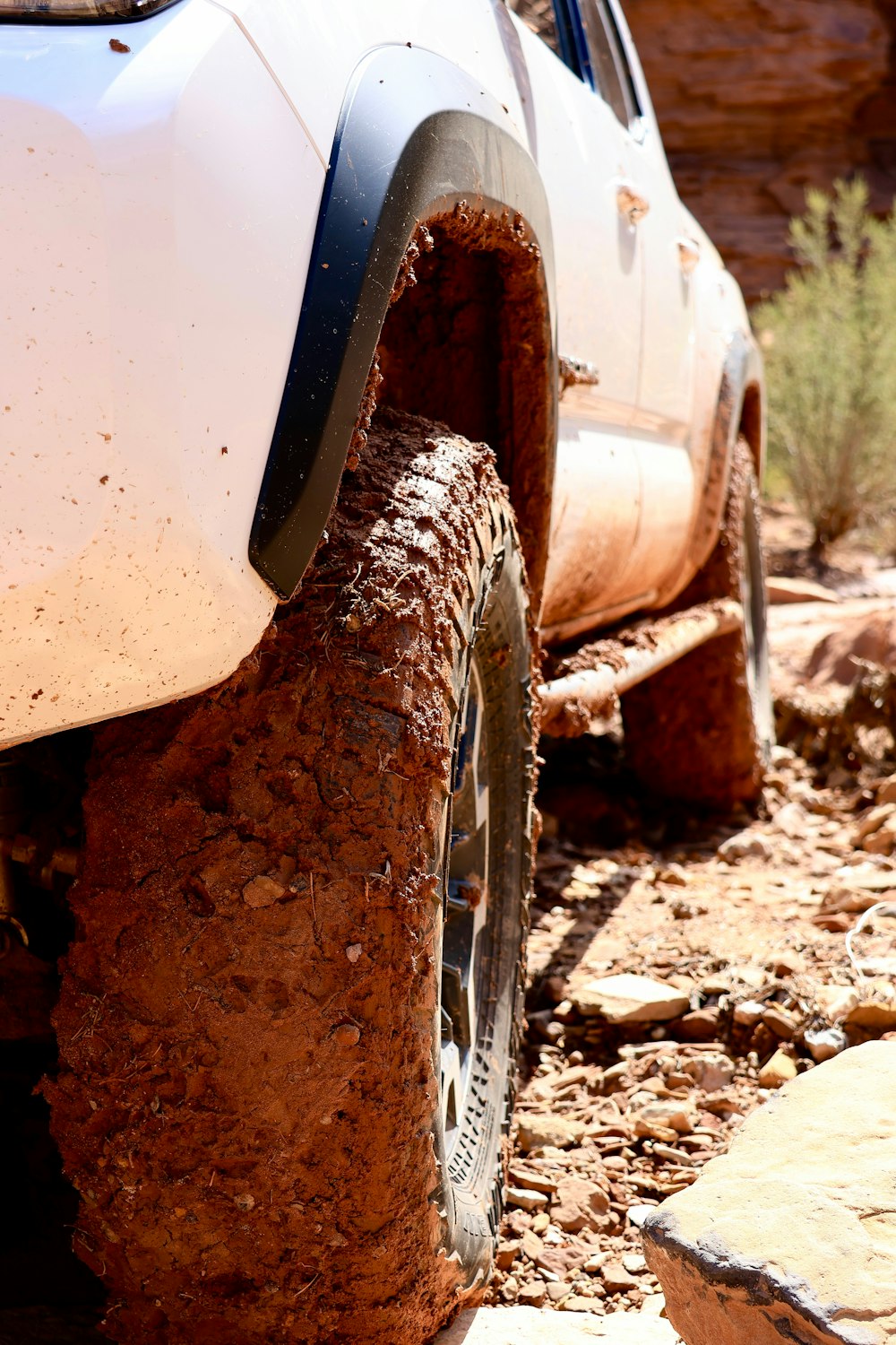 a white truck with mud all over it's tires