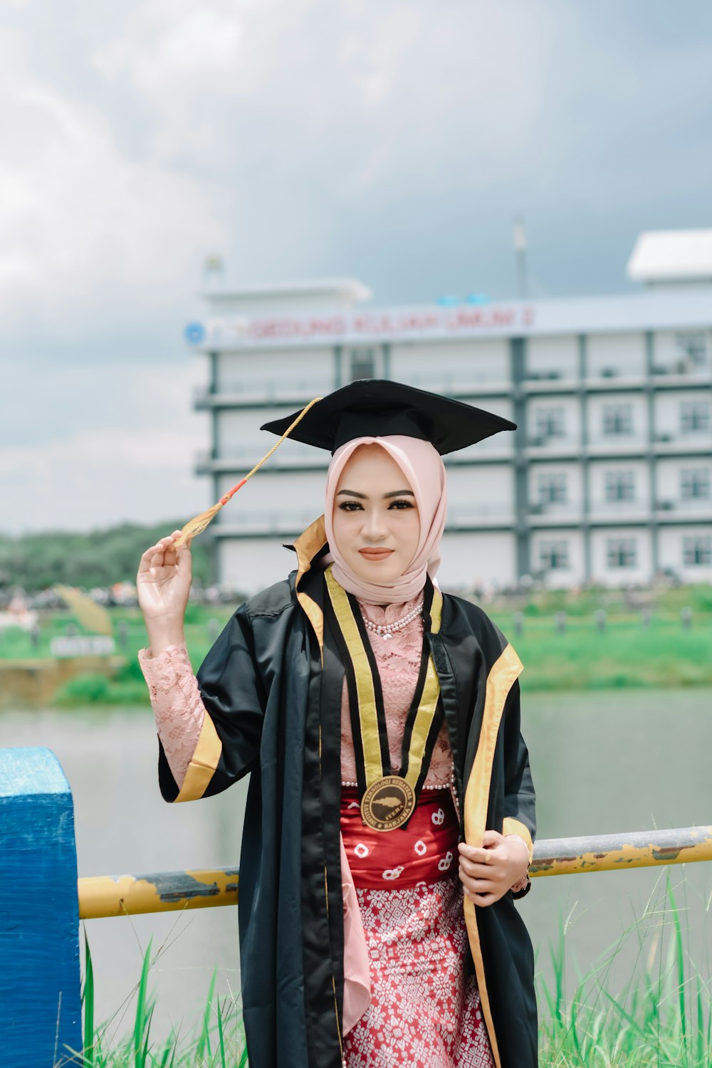 eine Frau in einem Abschlusskleid mit Diplom in der Hand