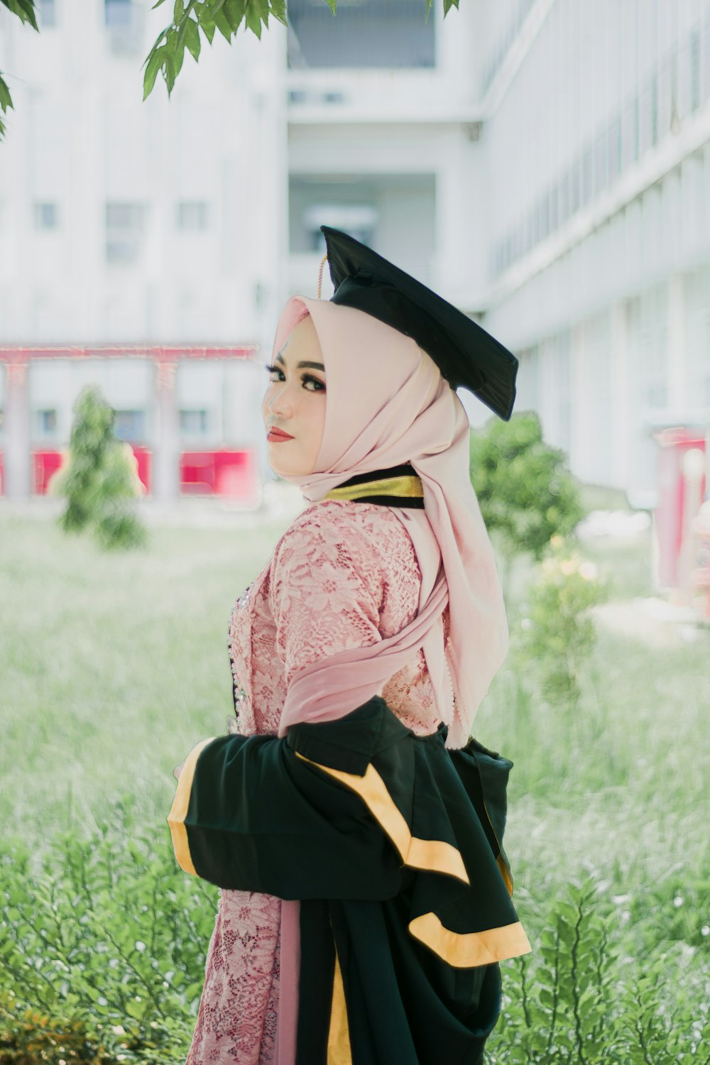 a woman in a hijab is standing in a field