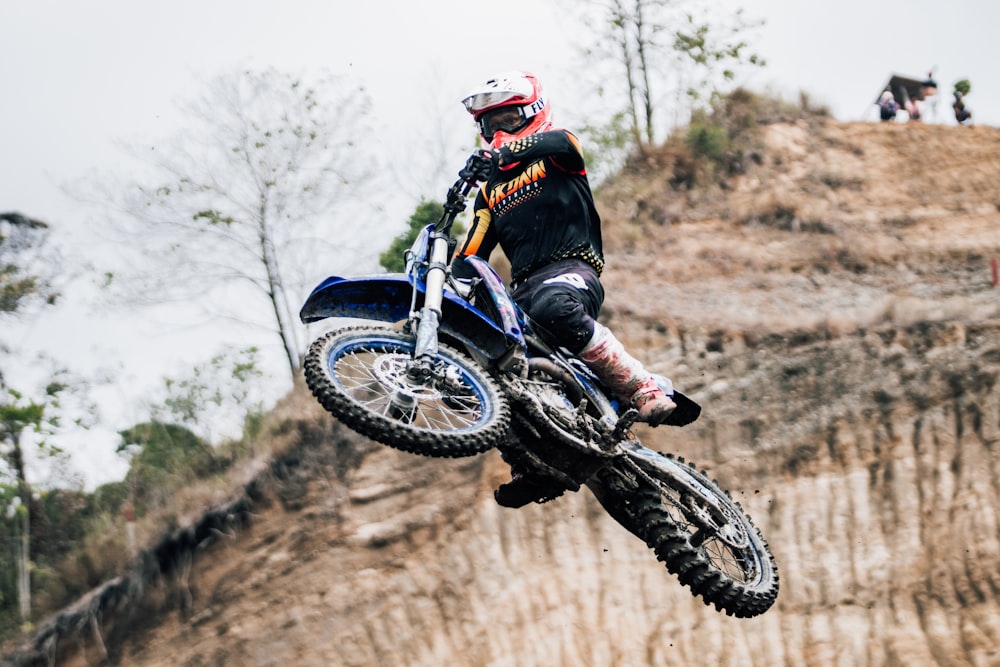 a man riding a dirt bike up the side of a hill