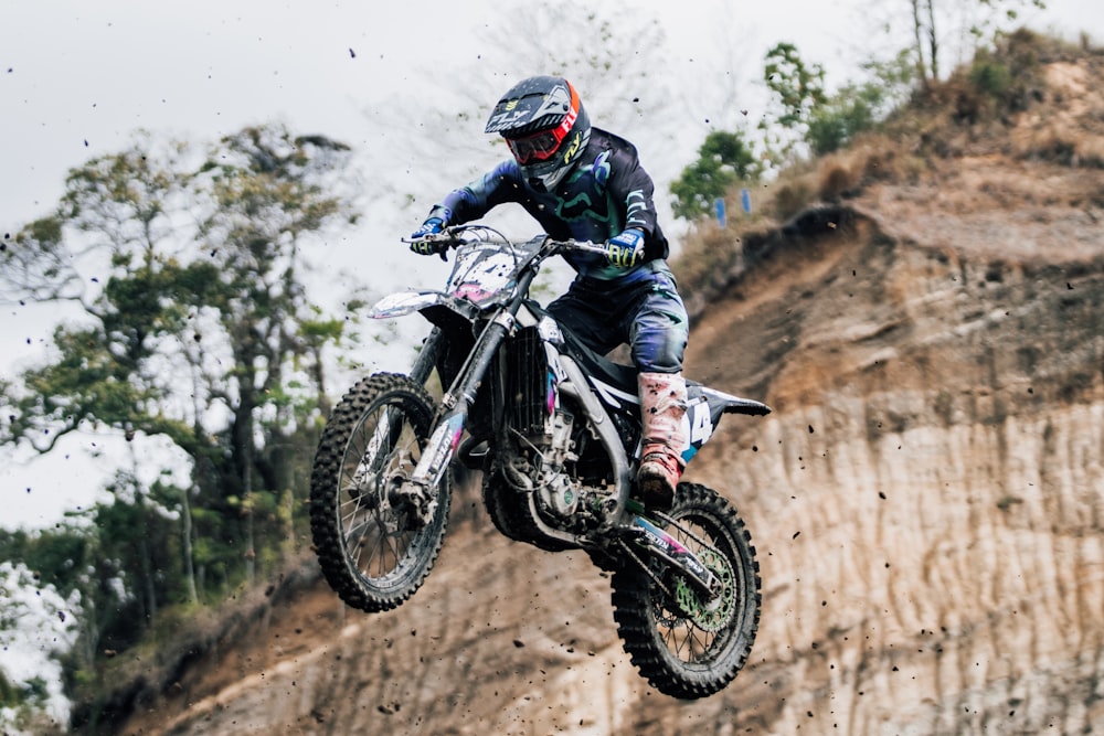 a man riding a dirt bike in the air