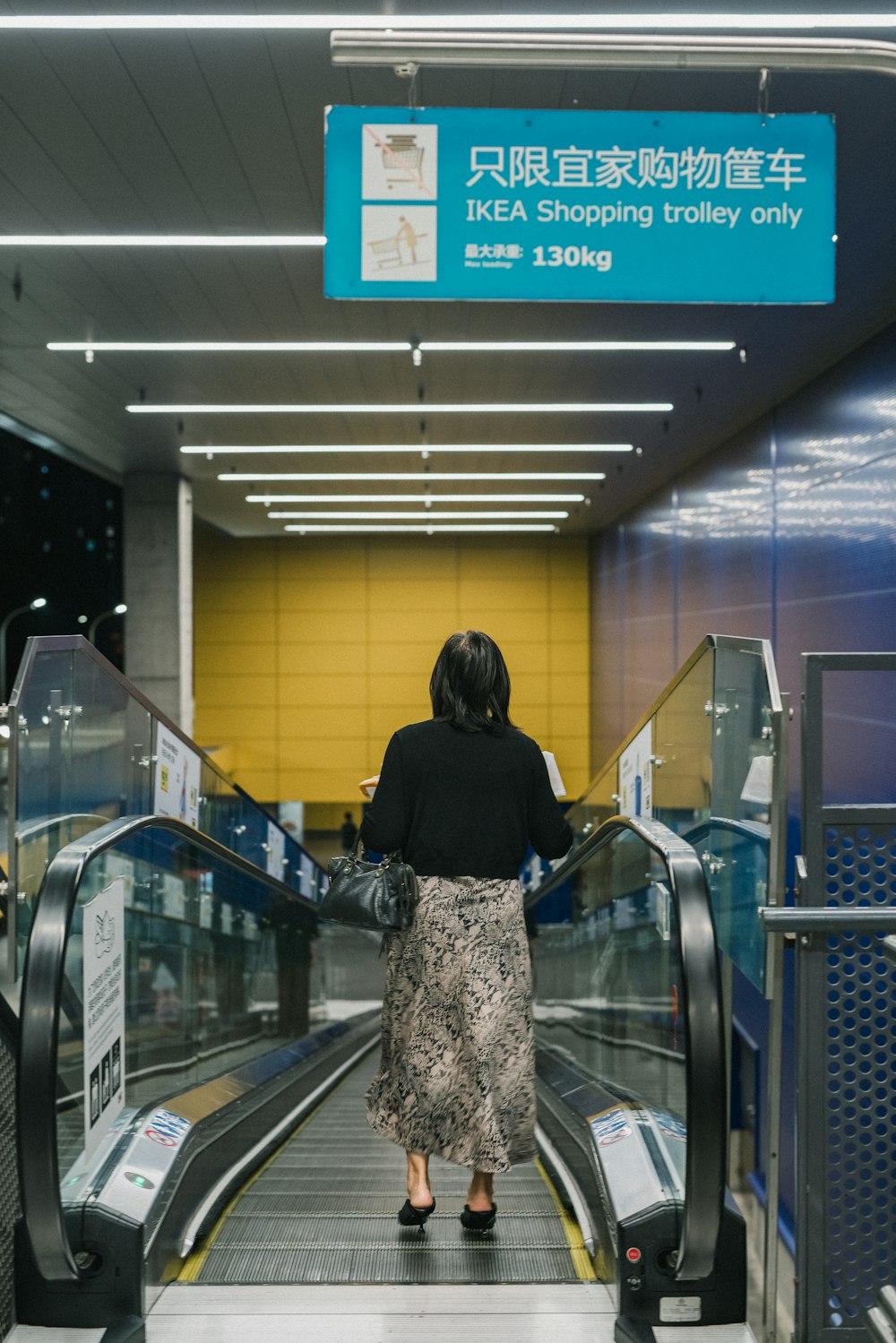 a woman walking down an escalator in an airport