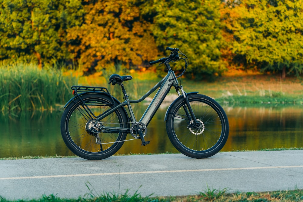 a bike parked on the side of a road next to a body of water