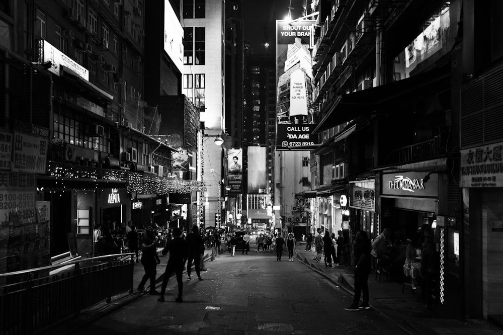 a black and white photo of a city street at night