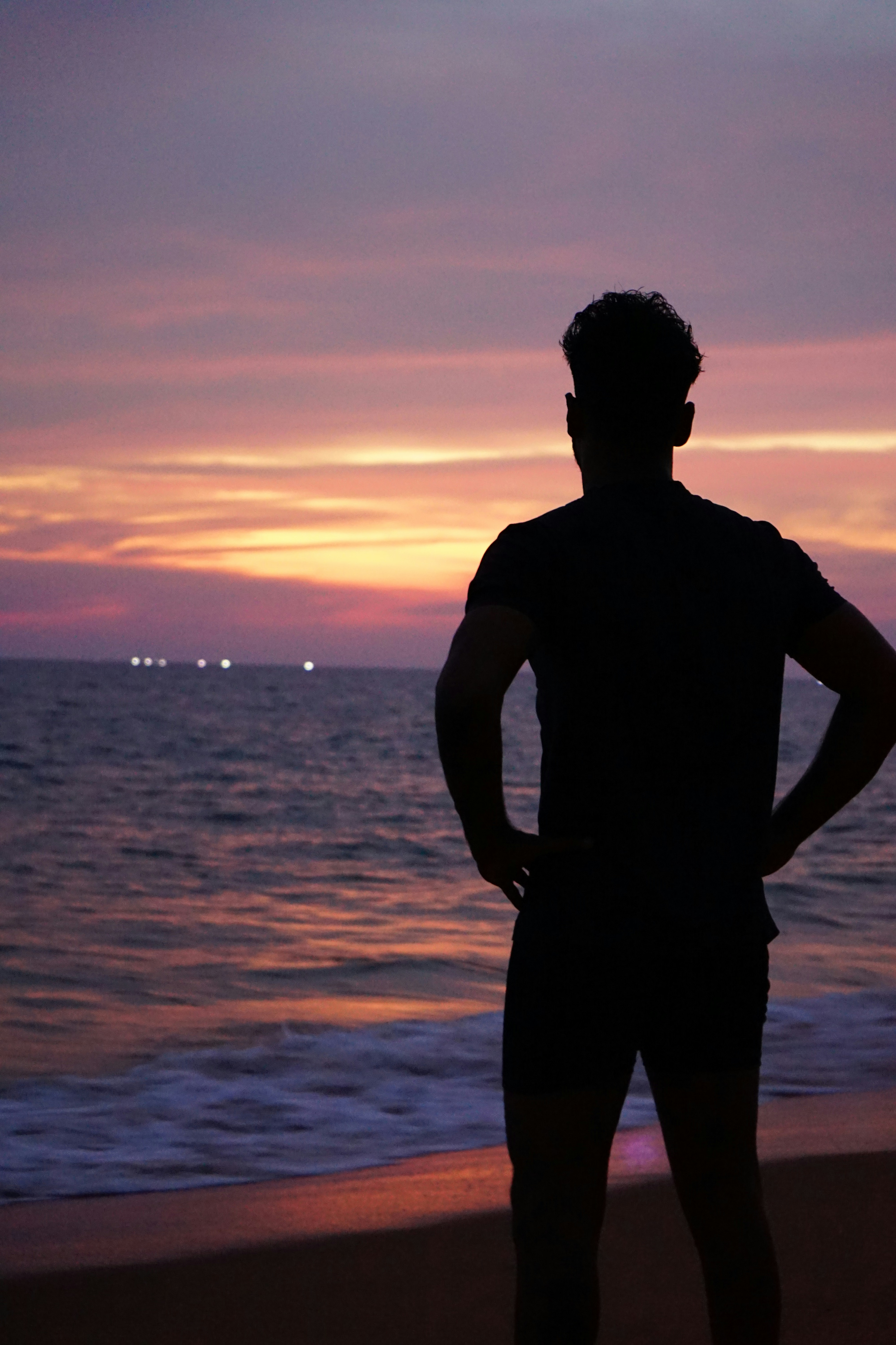 a man standing on top of a beach next to the ocean