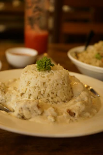 a white plate topped with rice covered in gravy