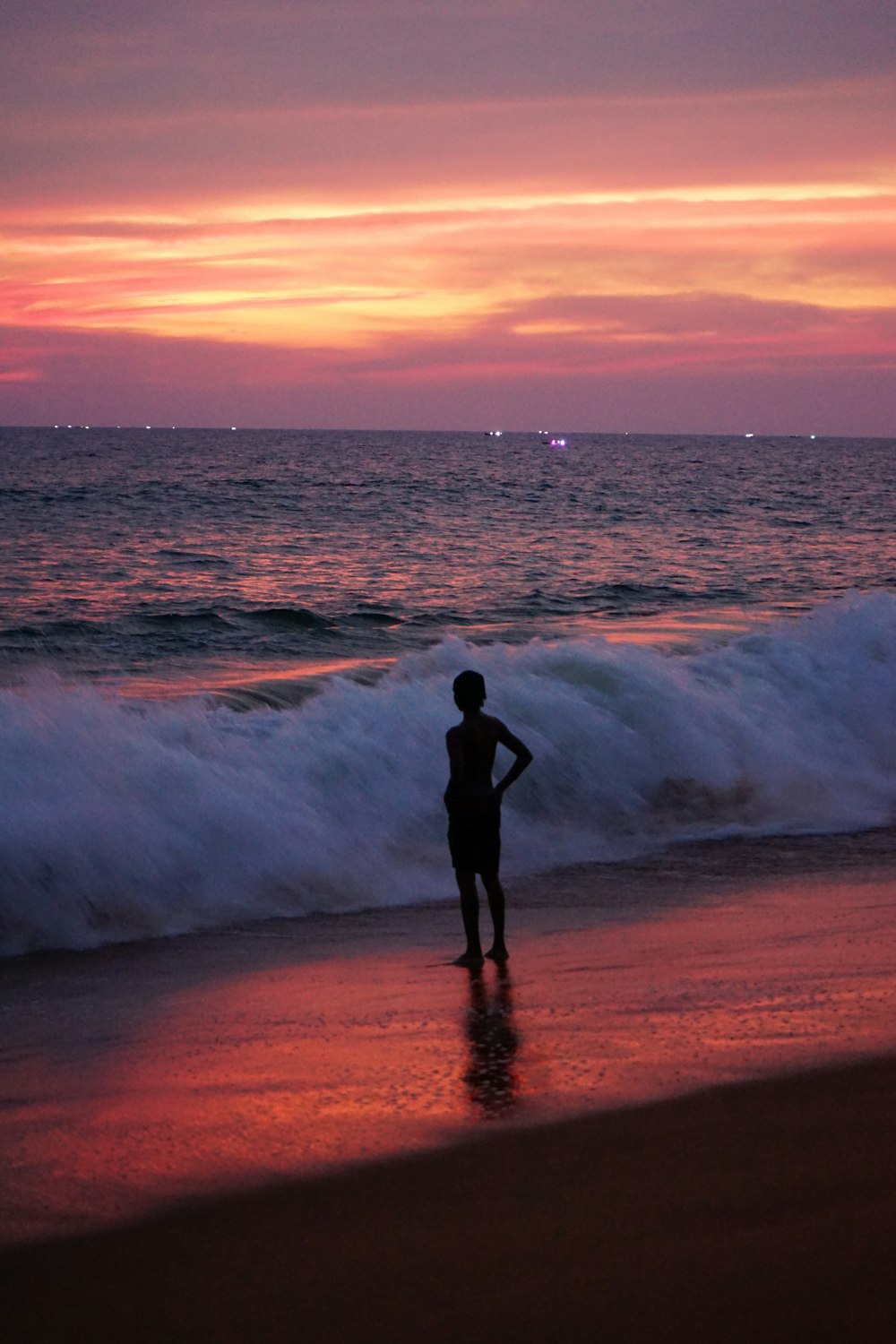 a man standing on a beach next to the ocean