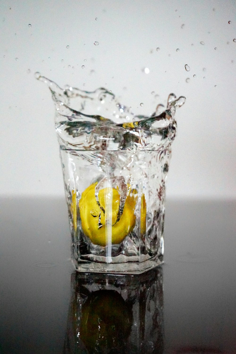 a glass of water with a banana in it